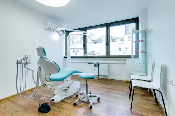 Moderner Zahnarztpraxis Raum mit Behandlungsstuhl und zahnmedizinischer Ausstattung.